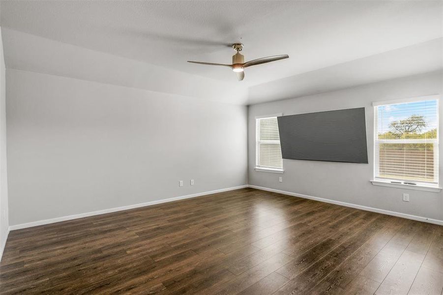 Unfurnished room with ceiling fan and dark hardwood / wood-style floors