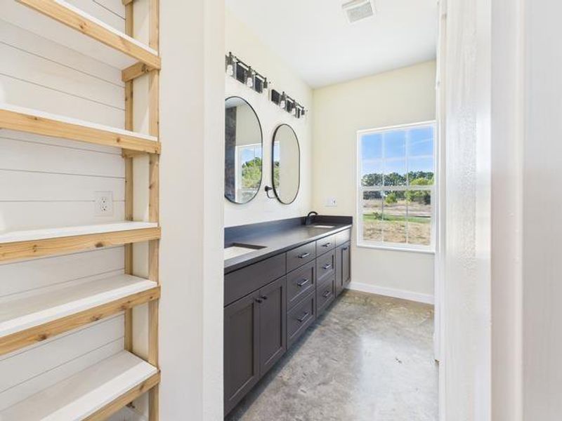 Before Photo bath with double vanity and unfinished concrete floors