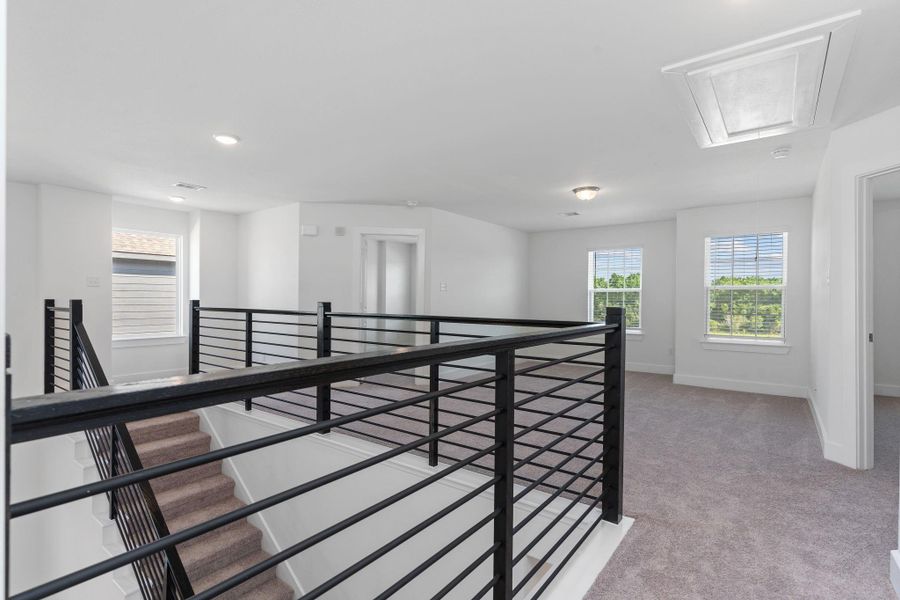 Take in the stunning second-floor catwalk, overlooking the grand living area and entry below. Modern iron railing and abundant natural light make this space feel open, connected, and beautifully designed. Take in the stunning second-floor catwalk, overlooking the grand living area and entry below. Modern iron railing and abundant natural light make this space feel open, connected, and beautifully designed.