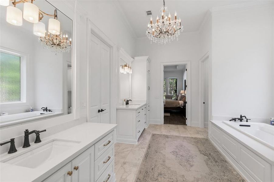 A view back to the primary bedroom. The walk in closet is to die for. Generously sized, the walk in closet features a large built-in dresser, tons of space for your clothes and shoes. The closet conveniently leads to the utility room.