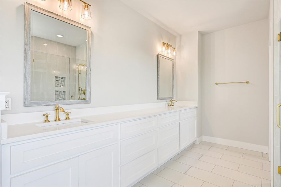 Dual vanities, designer fixtures, and extensive storage bring style and convenience to daily routines. Bright finishes and thoughtful design create a spa inspired atmosphere throughout.