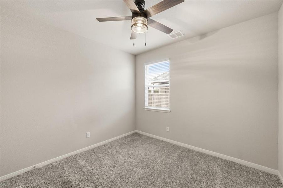 Spare room featuring carpet flooring and a ceiling fan