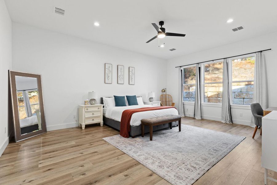 Bedroom featuring multiple windows, ceiling fan, light wood-style flooring, and recessed lighting