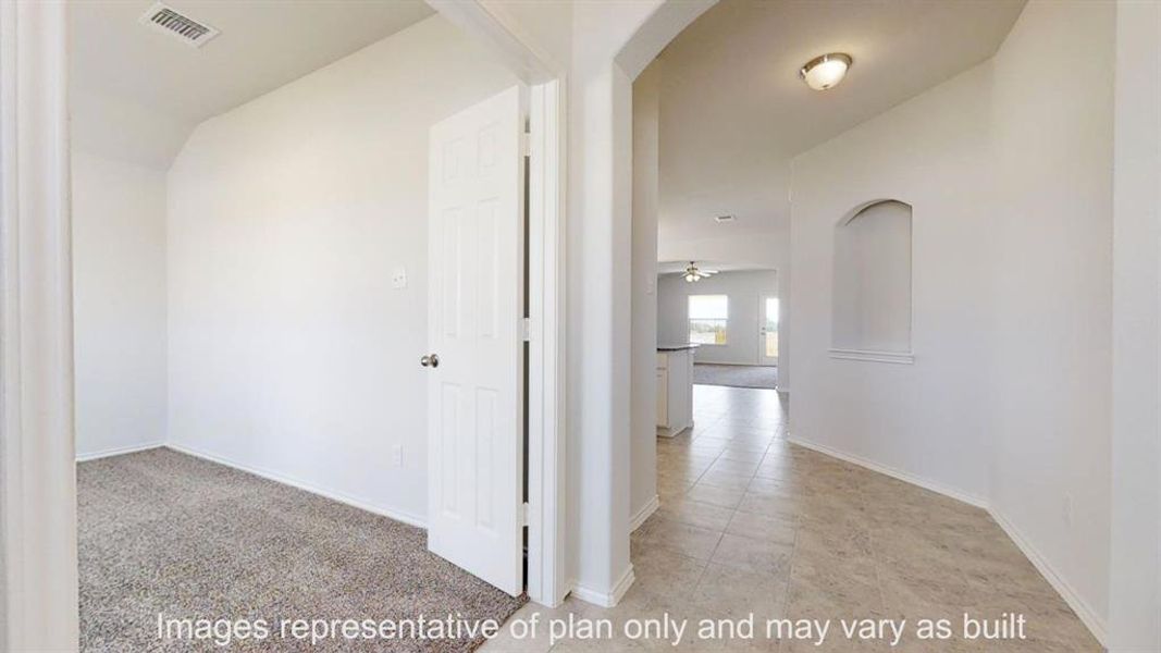 Hallway featuring arched walkways and light colored carpet Hallway featuring arched walkways and light colored carpet