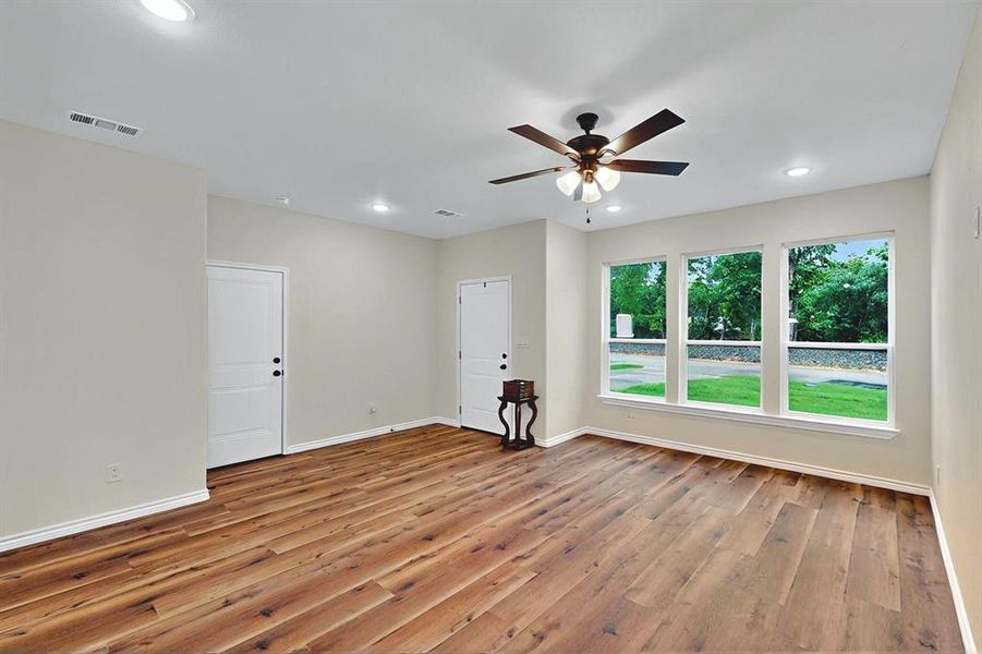 Unfurnished room featuring wood-type flooring, visible vents, baseboards, ceiling fan, and recessed lighting Unfurnished room featuring wood-type flooring, visible vents, baseboards, ceiling fan, and recessed lighting