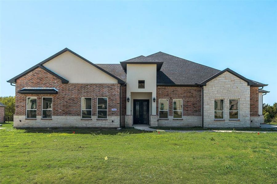 Contemporary facade featuring a mix of brick, stone, and stucco finishes Contemporary facade featuring a mix of brick, stone, and stucco finishes