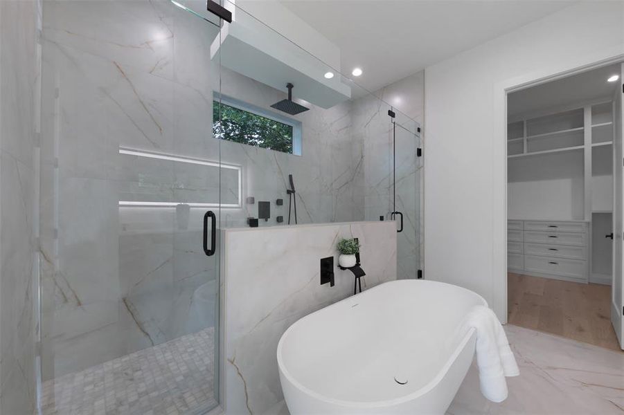 Bathroom with a marble finish shower, a freestanding bath, a walk in closet, recessed lighting, and marble finish floors