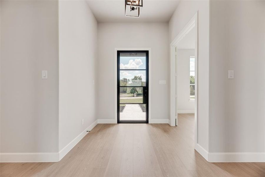 Foyer with light wood-style floors and baseboards