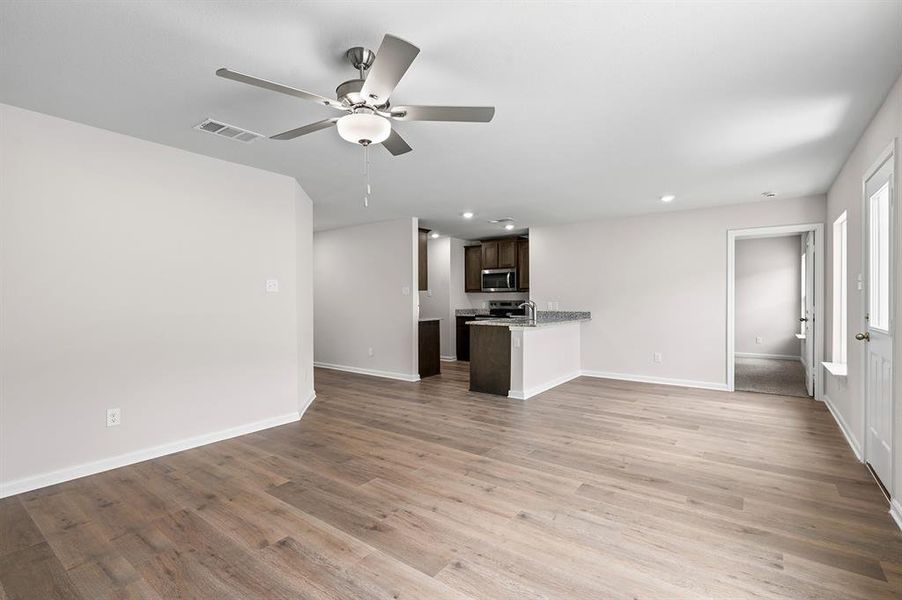 Unfurnished living room featuring a ceiling fan, recessed lighting, and light wood-style floors