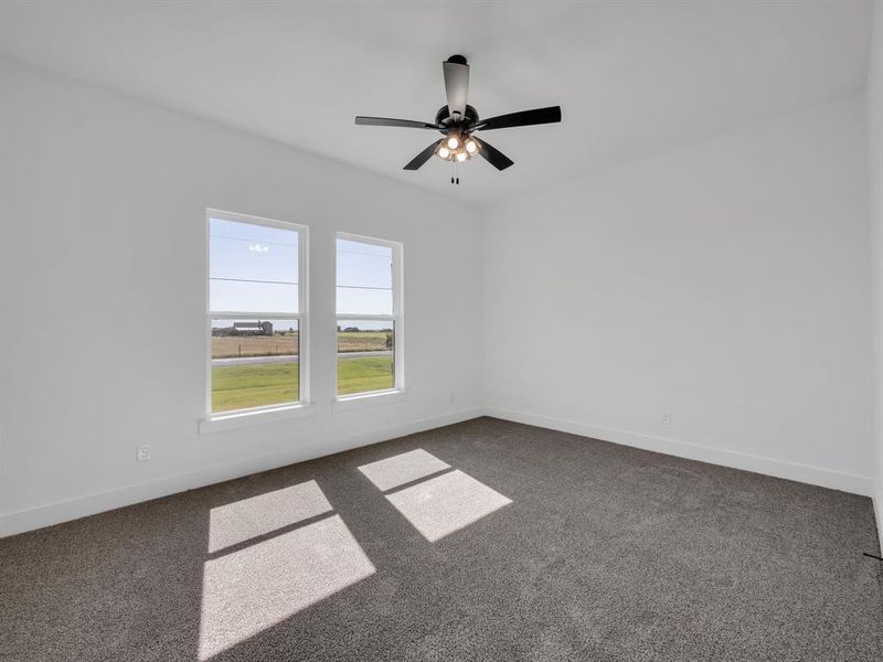 Spare room with dark carpet and ceiling fan