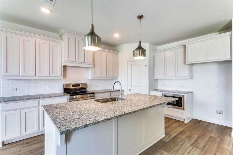 Kitchen featuring white cabinets, wood-type flooring, appliances with stainless steel finishes, and sink