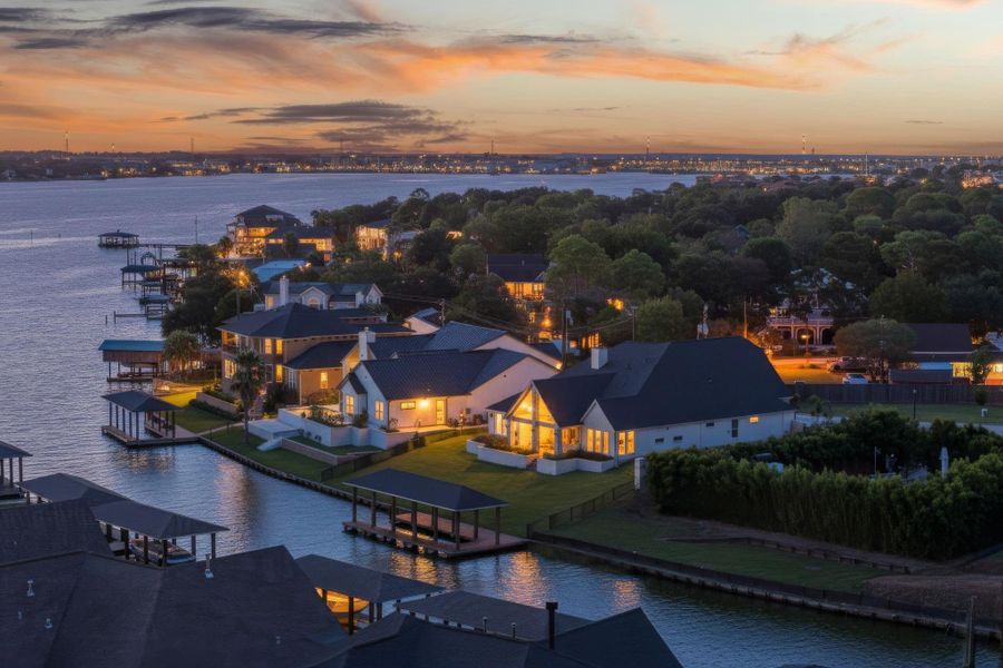 Aerial shot capturing the neighborhood and waterfront surroundings at sunset.