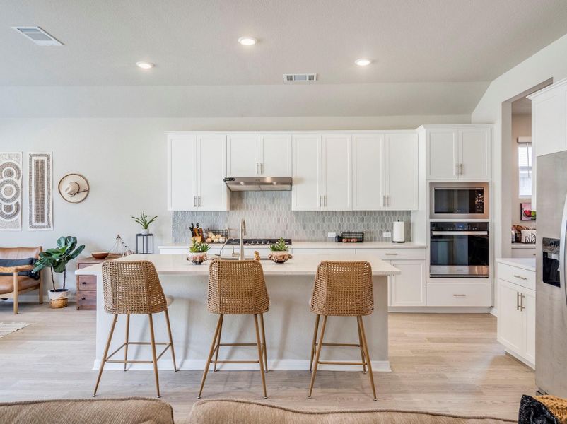 A well-lit culinary space showcases an elegant kitchen island with ample counter seating.
