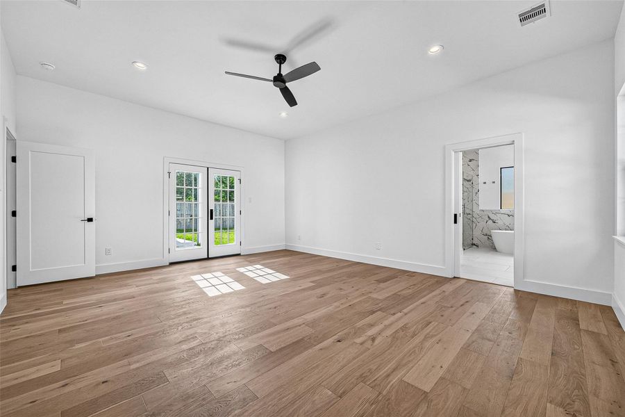 Primary bedroom with French doors leading out to patio Primary bedroom with French doors leading out to patio