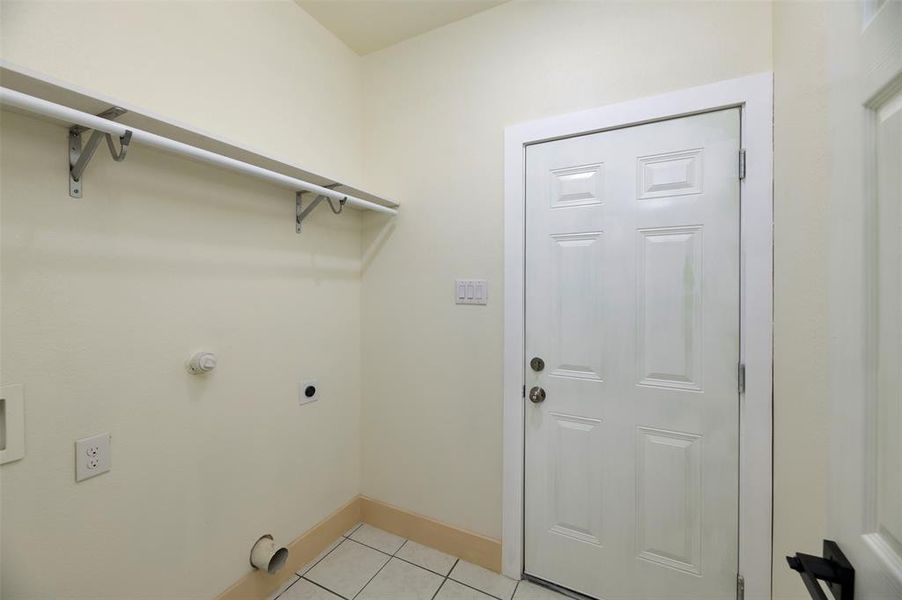Utility Room with space for full size washer and dryer with shelving. Opens to garage and kitchen.