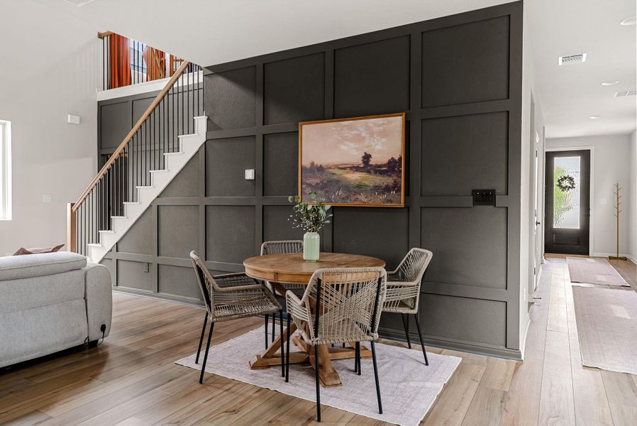 Dining room with a decorative wall and light wood-style floors
