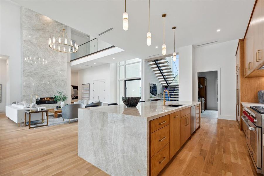 Kitchen with a towering ceiling, sink, and light wood-type flooring