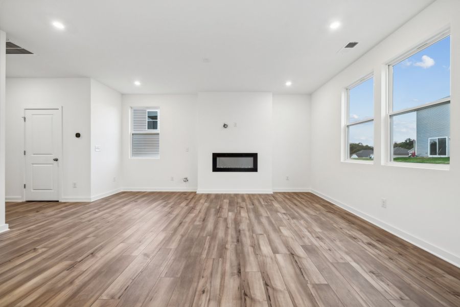 A room with a wood floor and a wood floor with a window. A room with a wood floor and a wood floor with a window.