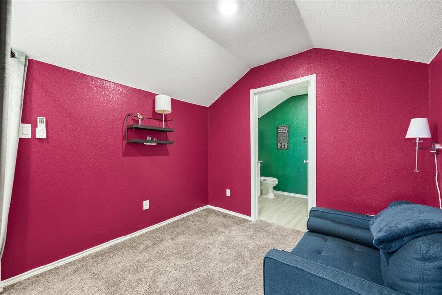 Sitting room with a textured wall and light colored carpet Sitting room with a textured wall and light colored carpet
