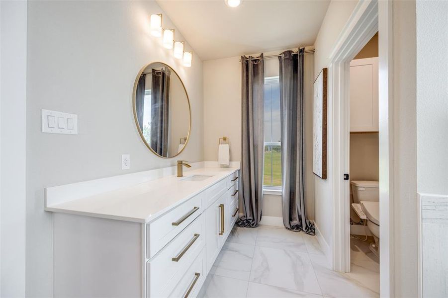 Full bath featuring vanity, light marble finish floors, and recessed lighting