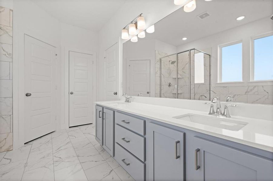 Primary bathroom with two sinks, separate shower and tub