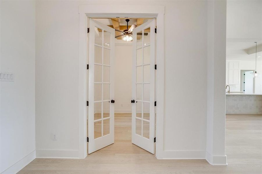 Hallway with french doors and light hardwood / wood-style flooring