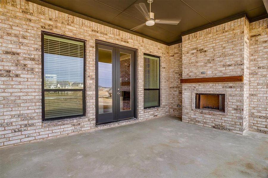 View of patio / terrace with an outdoor brick fireplace and ceiling fan