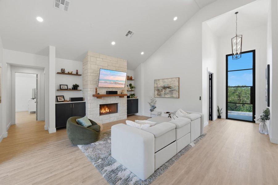 High vaulted ceilings and a stone fireplace define this light-filled main living space.