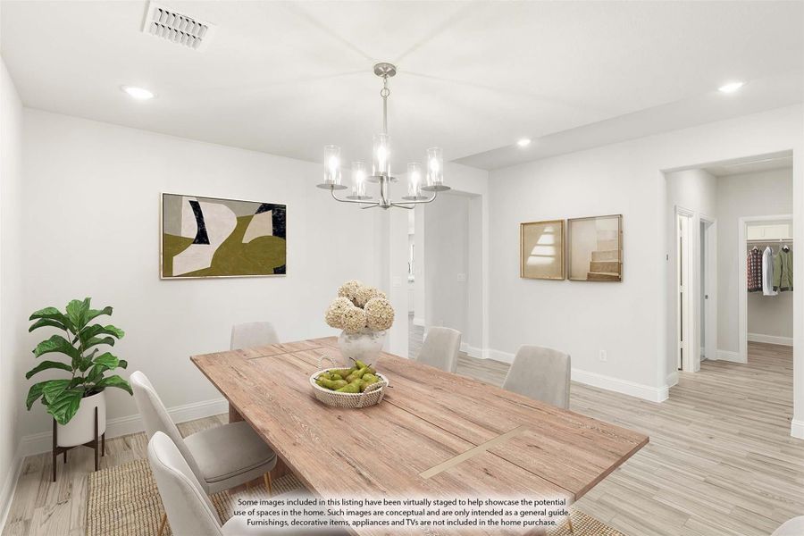 Dining room with wood table, upholstered chairs, chandelier, and light hardwood floors