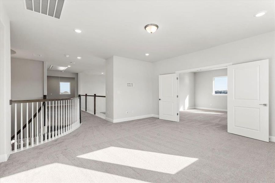 Empty room featuring light colored carpet and recessed lighting