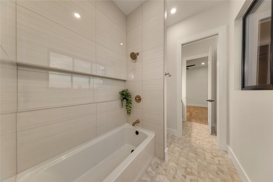 Bathroom with washtub / shower combination and recessed lighting