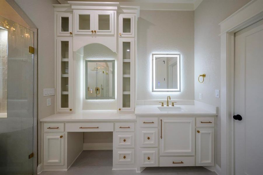 Full bathroom featuring a stall shower, vanity, and built in shelves Full bathroom featuring a stall shower, vanity, and built in shelves