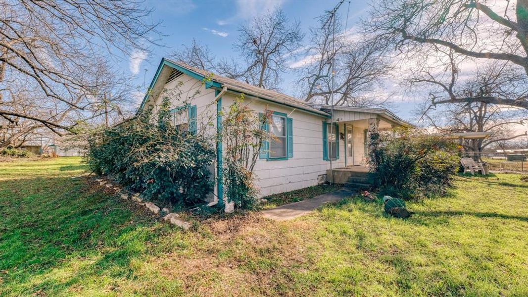 View of property exterior with a lawn