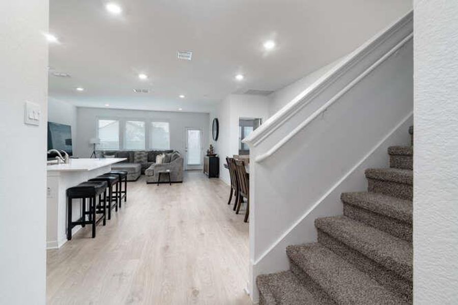 Stairway with wood finished floors and recessed lighting