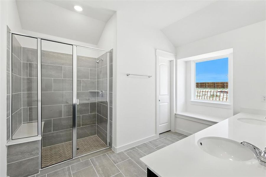 Bathroom featuring double vanity, a stall shower, wood finish floors, and vaulted ceiling Bathroom featuring double vanity, a stall shower, wood finish floors, and vaulted ceiling