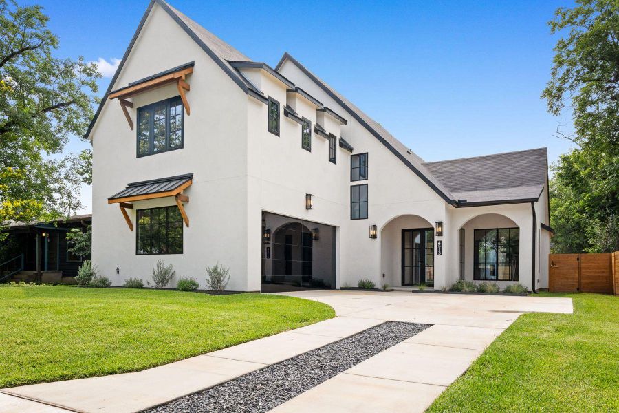 A modern facade with striking arched entries, clean white stucco, and a lush green lawn for exceptional curb appeal. A modern facade with striking arched entries, clean white stucco, and a lush green lawn for exceptional curb appeal.