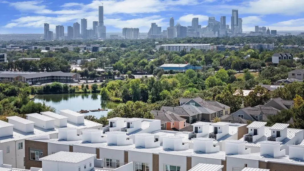 Aerial perspective of suburban area featuring a nearby body of water and city skyline Aerial perspective of suburban area featuring a nearby body of water and city skyline