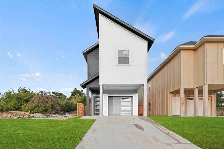 View of front of home with a garage and a front yard