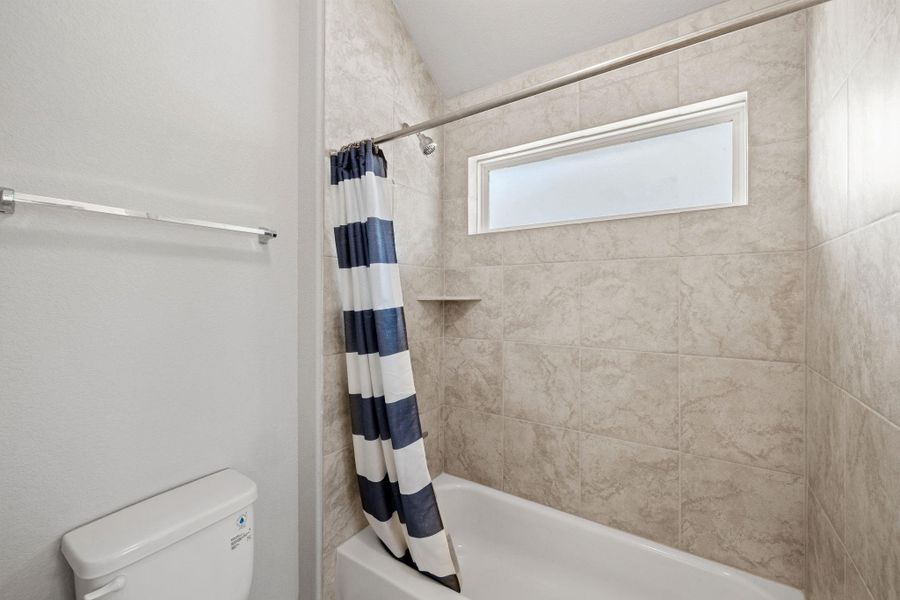 Bathroom with shower / bath combination with curtain and toilet Bathroom with shower / bath combination with curtain and toilet