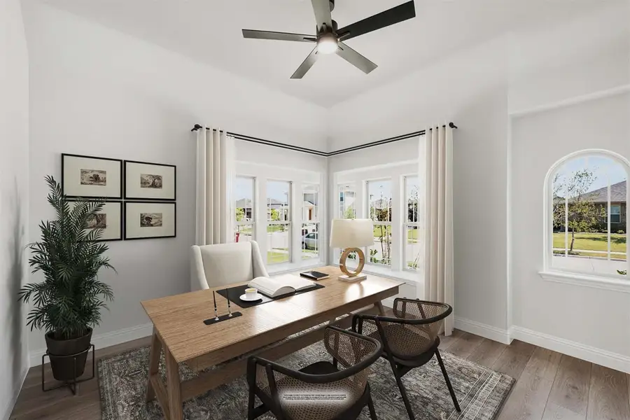 Home office with wood desk, ceiling fan, bay windows, and hardwood floors Home office with wood desk, ceiling fan, bay windows, and hardwood floors