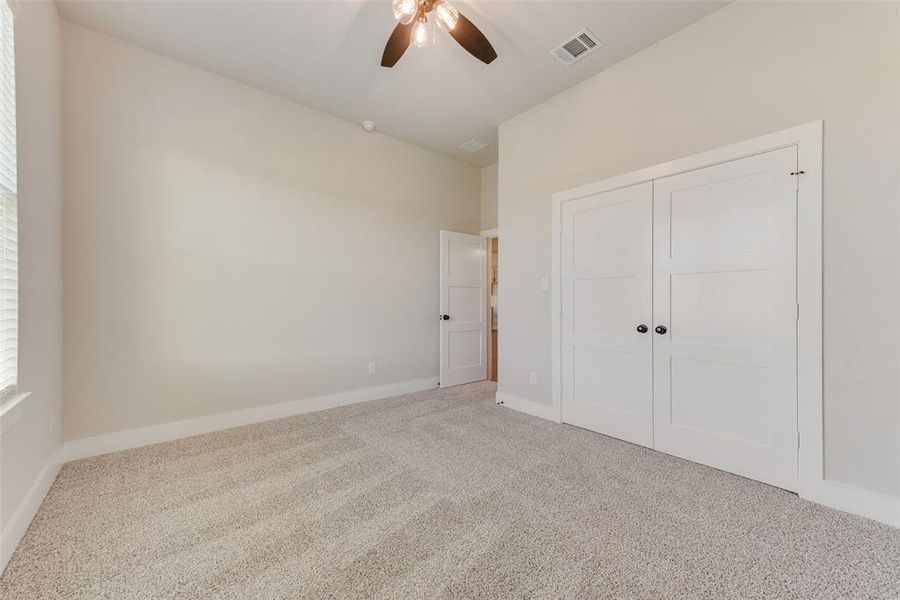 Unfurnished bedroom with carpet, ceiling fan, and a closet