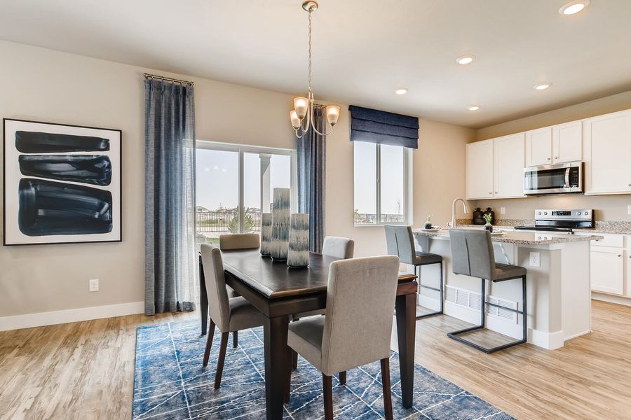 A kitchen with a dining table and chairs.