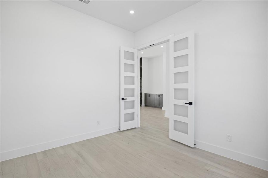 Study Room featuring french doors, light Porcelain Tile-finish flooring, white walls, and recessed lighting and front facing window.