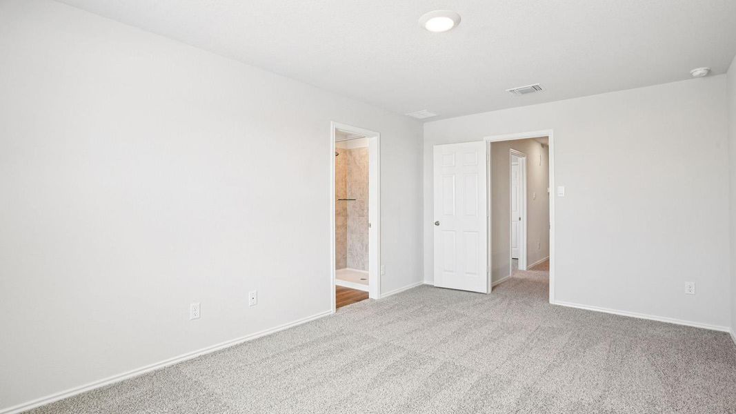 Spacious interior room featuring light gray carpeting and neutral wall tones