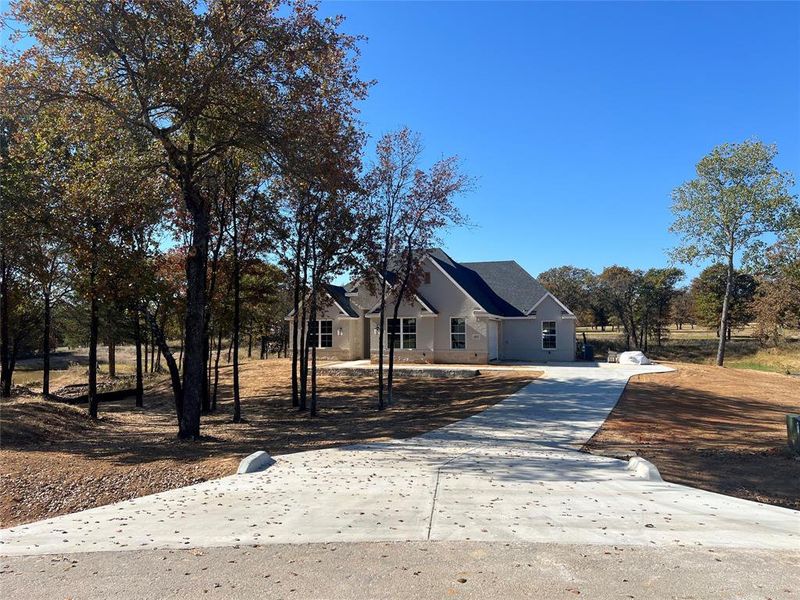 Front exterior of a new home in Escondido Ranches, Poolville, TX, highlighting curb appeal (Image 14).