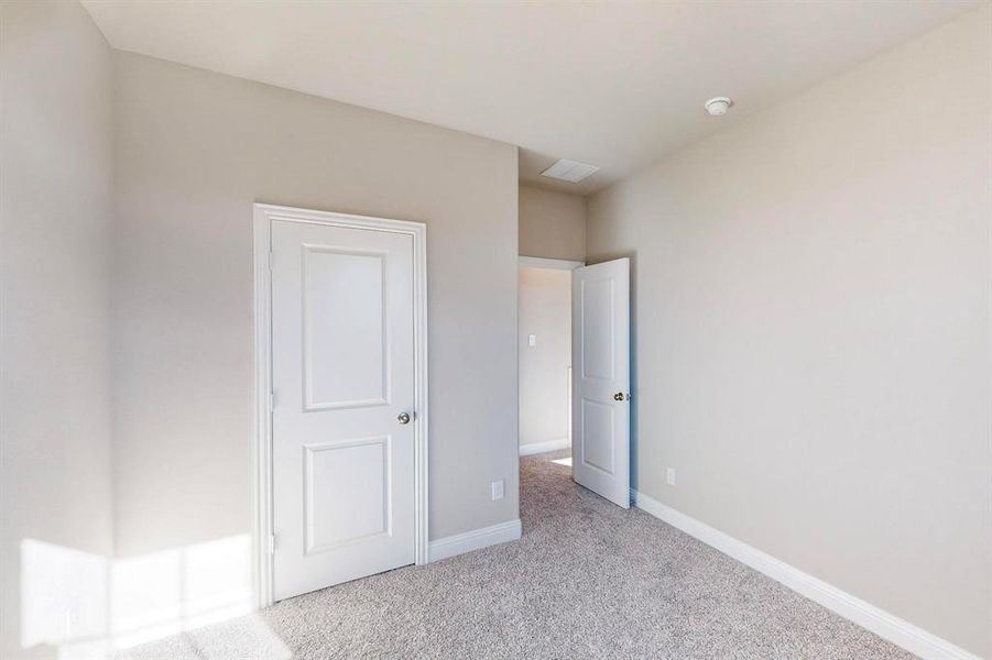 Unfurnished bedroom with light colored carpet