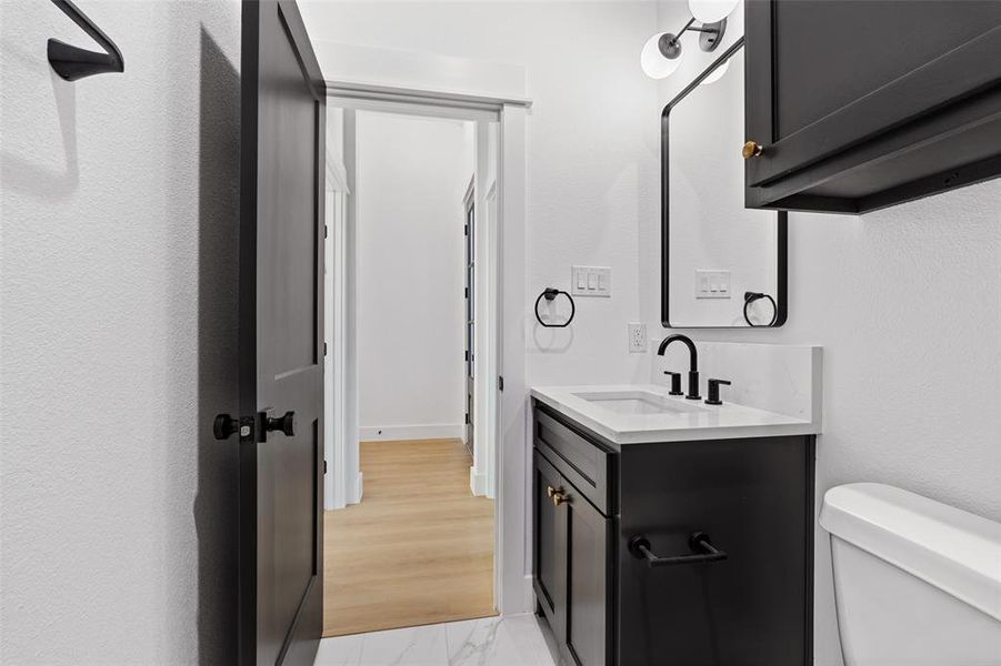 Bathroom featuring hardwood / wood-style floors, vanity, and toilet