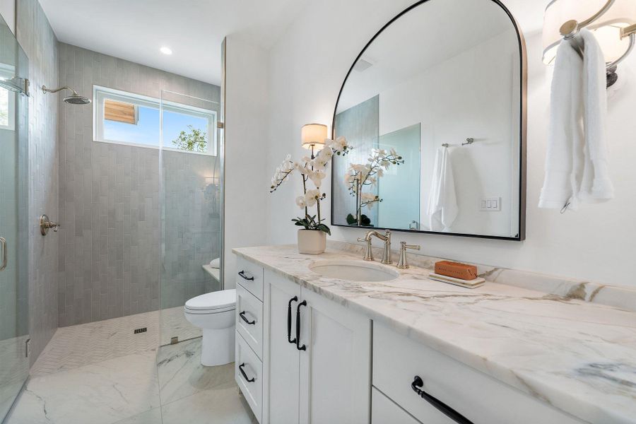 Bathroom with a stall shower, vanity, and recessed lighting Bathroom with a stall shower, vanity, and recessed lighting