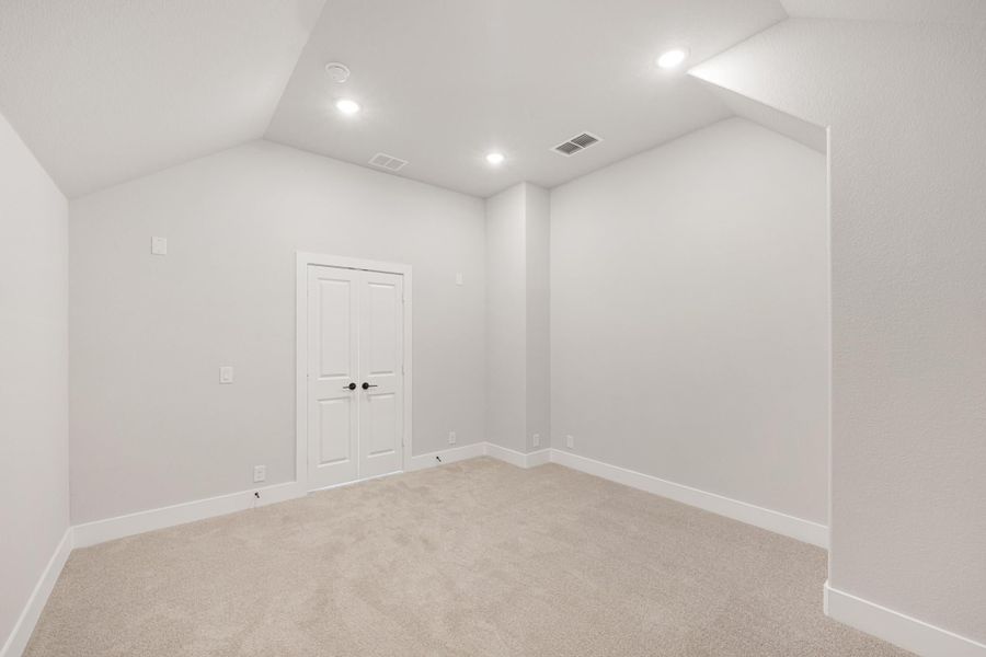 Empty room with beige carpet, white walls, recessed lighting, and double doors Empty room with beige carpet, white walls, recessed lighting, and double doors