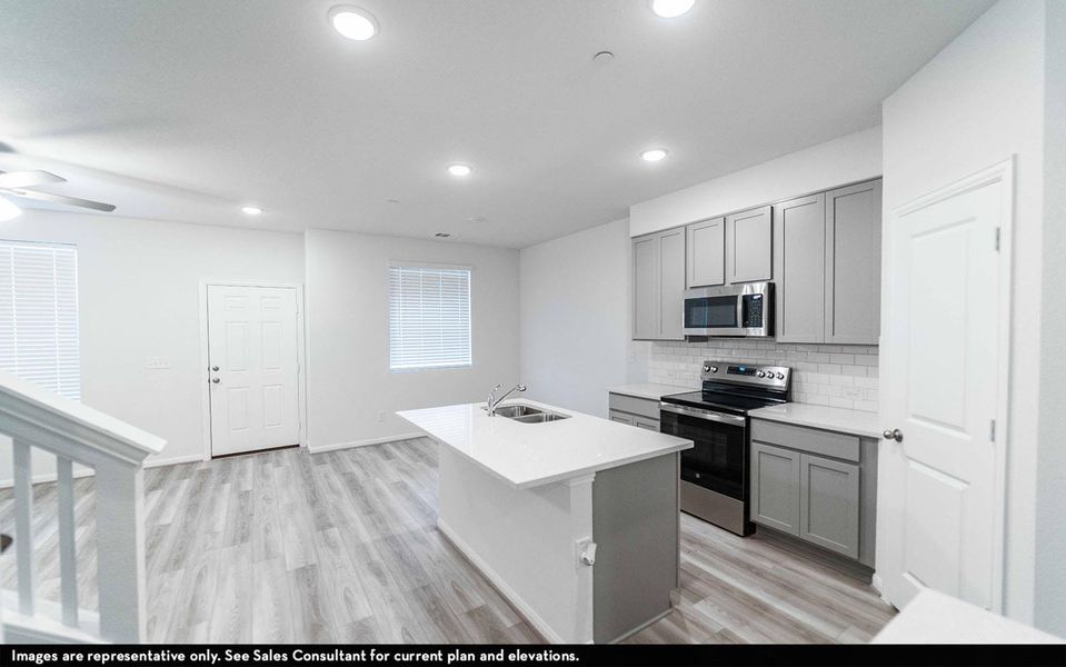 Kitchen featuring stainless steel appliances, gray cabinetry, light wood finished floors, an island with sink, and recessed lighting